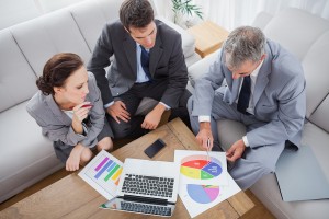 Business people analyzing diagrams together in cosy meeting room