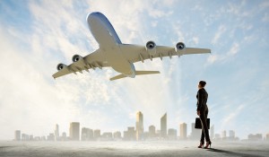 Image of business woman holding suitcase looking at airplane in