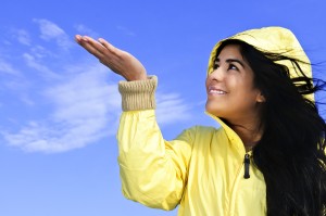 Portrait of beautiful smiling girl wearing yellow raincoat looki