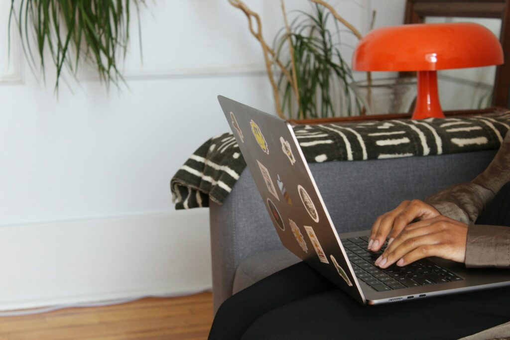 Person using a laptop on a couch.