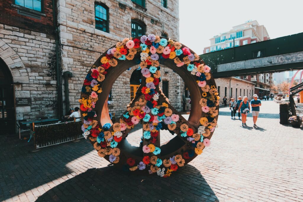 An art installation featuring a peace sign covered in flowers at the Distillery District in Toronto.