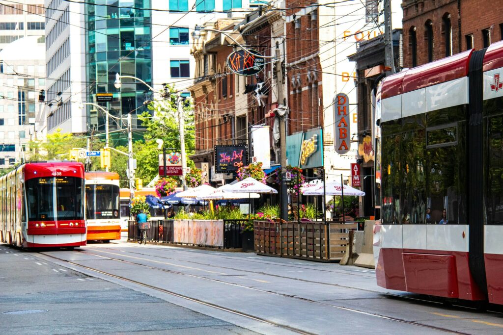 Cityscape scene in downtown Toronto with streetcars and signage.